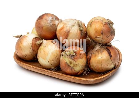 Fresh yellow onion heap on wooden plate isolated on white background Stock Photo