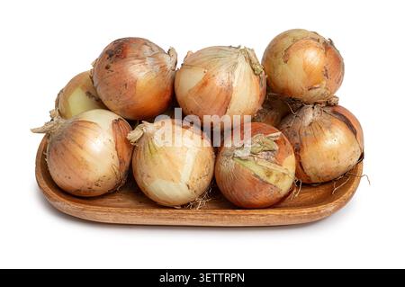 Fresh yellow onion heap on wooden plate isolated on white background Stock Photo