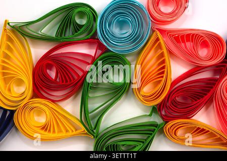 Patterns from strips of colored paper using the quilling technique. Multicolored ornament on a white background. Stock Photo
