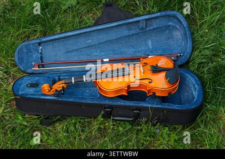violin and bow in a case on the grass, close-up. 1/4 children's violin Stock Photo