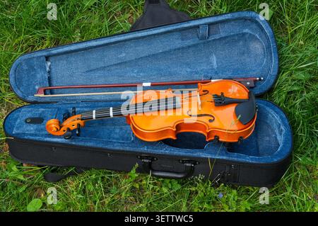 violin and bow in a blue case on a green grass background Stock Photo
