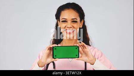 Phone, happy and nurse in studio with green screen, medical info and announcement with space. Portrait, mockup and woman with cellphone for telehealth Stock Photo