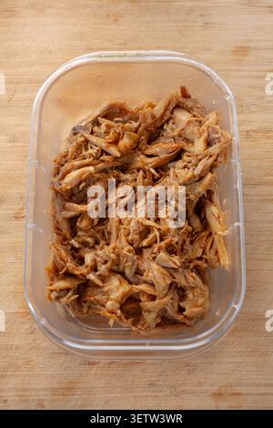 A view of a food plastic container of crockpot BBQ chicken on a plate. Stock Photo