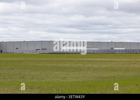Industrial warehouse building exterior with green grass field Stock Photo