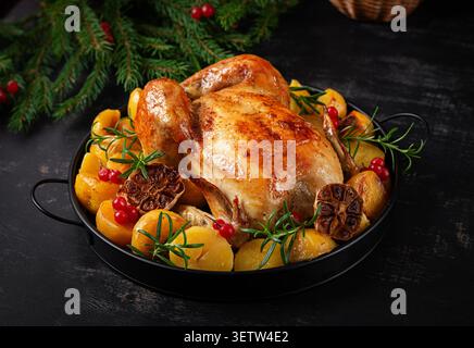 Golden Roasted Chicken with Potatoes and Rosemary on Festive Holiday Table Stock Photo