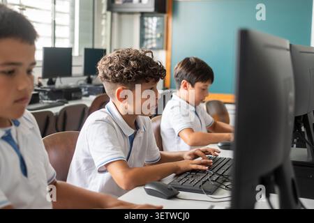 Group of primary school students working on desktop computers during an information technology class. Stock Photo