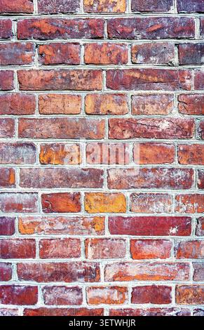 Grunge weathered red brick wall as background texture. Bricks masonry with uneven seams Stock Photo