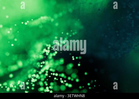 Abstract green bokeh background with glowing particles, fluid smoke effects, and depth of field. Perfect for futuristic technology, digital data, or o Stock Photo