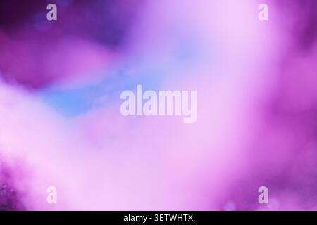 An abstract blurred background featuring soft neon purple, violet, and hot pink tones with a touch of blue. Ethereal smoky texture creates a dreamy, c Stock Photo