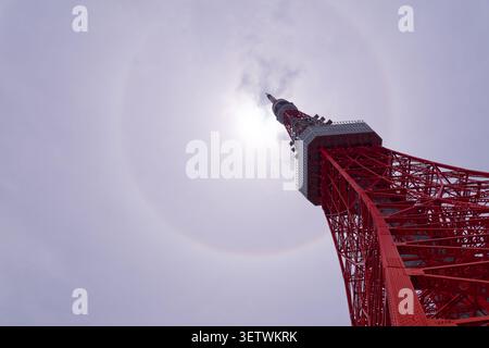 Low Angle View of Tokyo Tower Beneath Rare Circular Solar Halo, Dramatic Atmospheric Phenomenon in the Sky Above Tokyo Japan Stock Photo