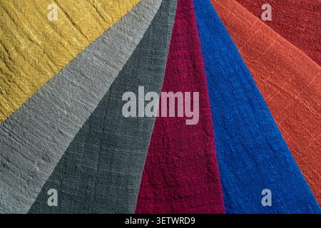 Colorful textured cotton fabric swatches background. Flat lay of various crinkled cotton or linen fabric samples arranged in stripes showing rich text Stock Photo
