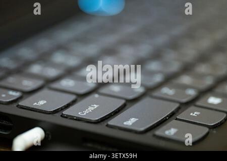 Close up view of a laptop keyboard with focus on the Caps Lock key. Simple tech background for work, typing, office and digital concepts Stock Photo