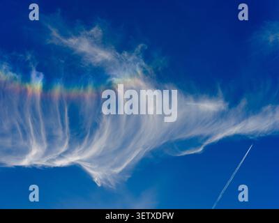 Iridescent clouds form over southern England a visual phenomenon showing colours within the cloud formation. Stock Photo