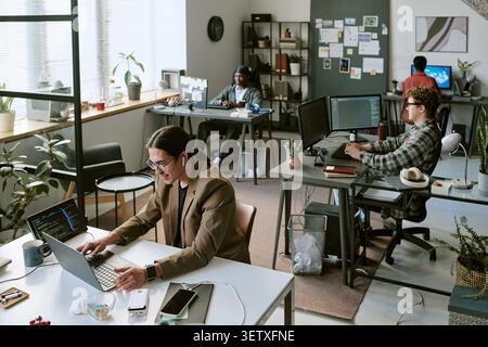 Diverse Office Team Working on Computers in Modern Creative Workspace Stock Photo