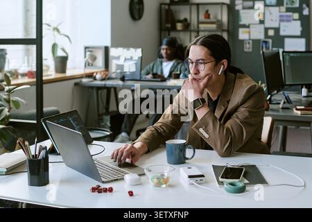 Adult Man Working on Laptop in Creative Office Startup Environment Stock Photo