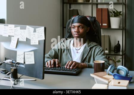 Black Man Working at Desktop Computer in Office Stock Photo