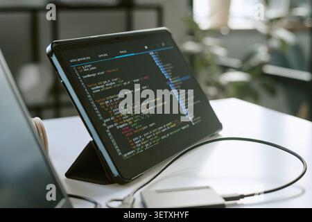 Tablet Displaying Software Code for App Development Workspace Stock Photo