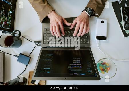 Adult Man Typing Code on Laptop for Remote Software Development Stock Photo