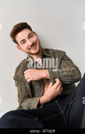 Charming young man poses with confidence in a trendy outfit, highlighting his style Stock Photo