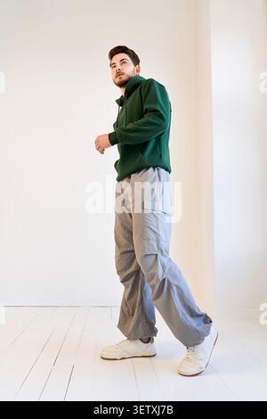 Charming young man with a beard poses confidently in a fashion-forward casual outfit Stock Photo
