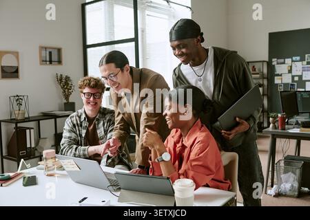 Diverse Adult Coworkers Collaborating on Digital Project in Office Stock Photo