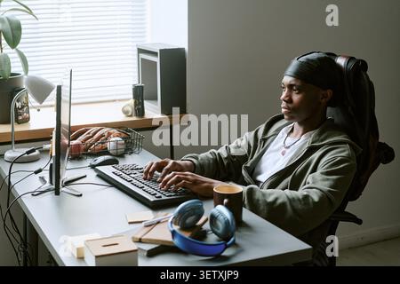Black Man Typing at Desktop Computer in Office Stock Photo