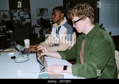 Multiethnic Men Working on Digital Devices in Modern Office Stock Photo