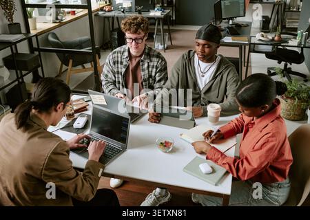 Diverse Coworkers Collaborating on Digital Project in Modern Office Stock Photo