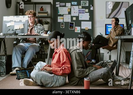 Diverse Adult Coworkers Collaborating on Coding in Startup Office Stock Photo