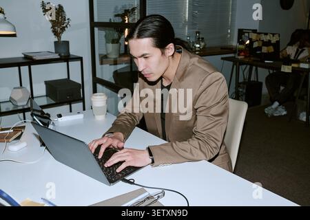 Adult Man Working on Laptop in Office during Late Shift Stock Photo