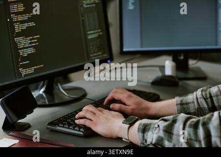 Adult Man Coding at Dual Monitors for Software Development Stock Photo