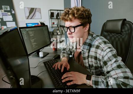 Adult Man Coding at Desk for Software Development Project Stock Photo