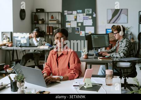 Portrait of Black Woman Working on Laptop in Creative Office Stock Photo