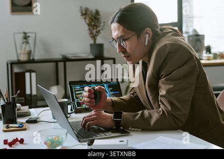 Asian Man Working on Laptop during Software Development Stock Photo