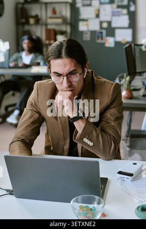 Adult Man Reviewing Laptop for Office Problem Solving Stock Photo