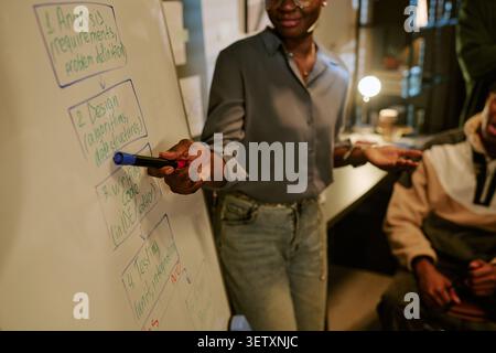 Black Woman Presenting Software Development Workflow to Team Stock Photo