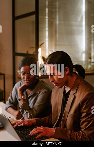 Business Colleagues Collaborating on Laptop during Office Meeting Stock Photo