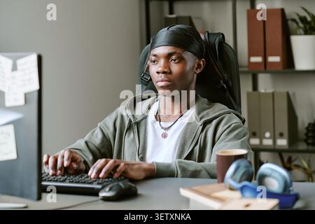 Black Man Working at Computer in Home Study Space Stock Photo