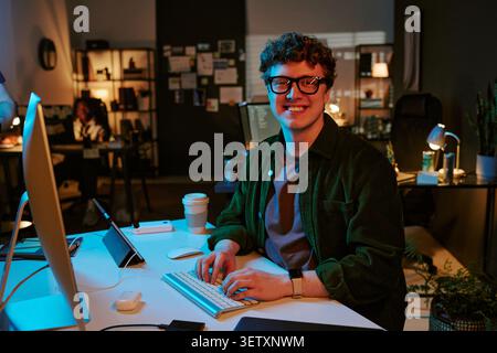 Portrait of Adult Man Working at Computer in Creative Office Stock Photo