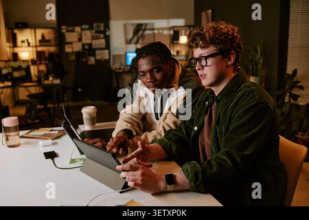 Workers Collaborating on Tablet for Digital Project Stock Photo