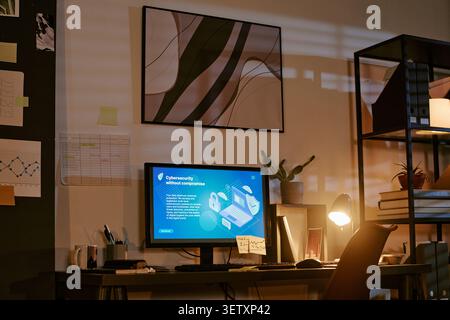 Office Workspace Displaying Cybersecurity Dashboard for Remote Work Stock Photo