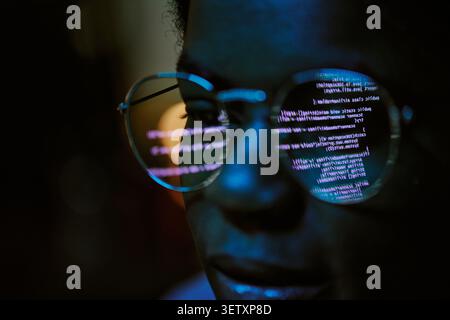 Black Woman Analyzing Code Reflection for Cybersecurity Work Stock Photo