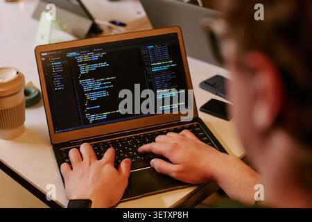 Adult Man Coding on Laptop for Software Development Workflow Stock Photo