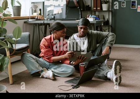 Black Coworkers Collaborating on Digital Project in Office Stock Photo