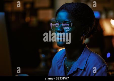 Black Woman Programmer Working Late on Cybersecurity Code Stock Photo