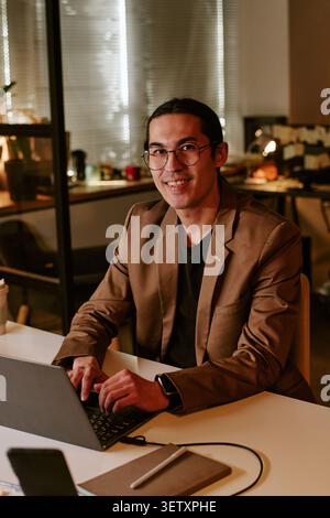 Portrait of Adult Man Working on Laptop in Modern Office Stock Photo