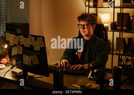 Adult Man Working at Computer in Office at Night Stock Photo