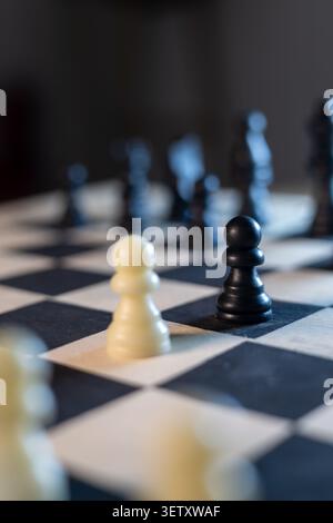 Black and White Chess Pawns Facing Each Other on Chessboard Stock Photo