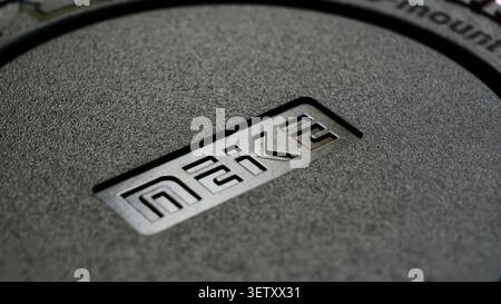 Meike logo engraved on a black camera body cap, showing a textured surface Stock Photo