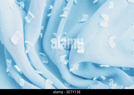 Top view full frame background of a crumpled light blue chiffon fabric texture with white tufted dots, showcasing elegant soft folds on a delicate air Stock Photo